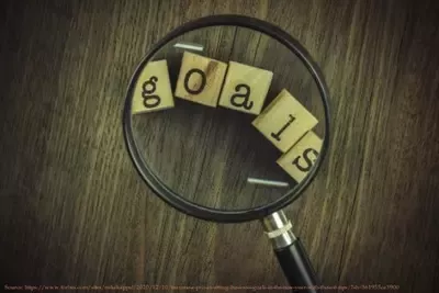 Image of magnifying glass over scrabble pieces spelling the word goals